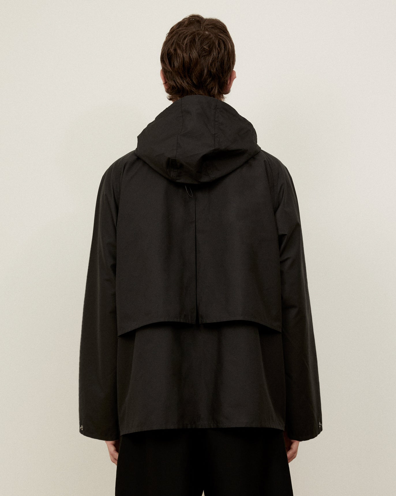 Morrow Australian Fashion black Dry Jacket back view with hood attached and storm flap in view